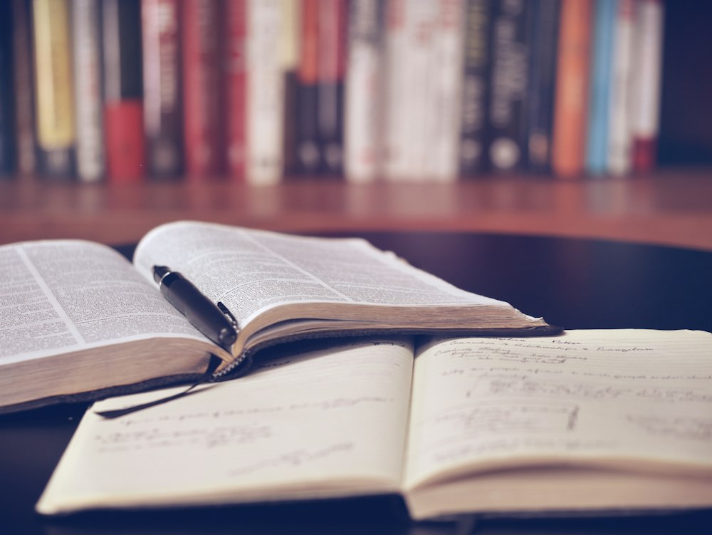 Open textbook and study notes on a desk