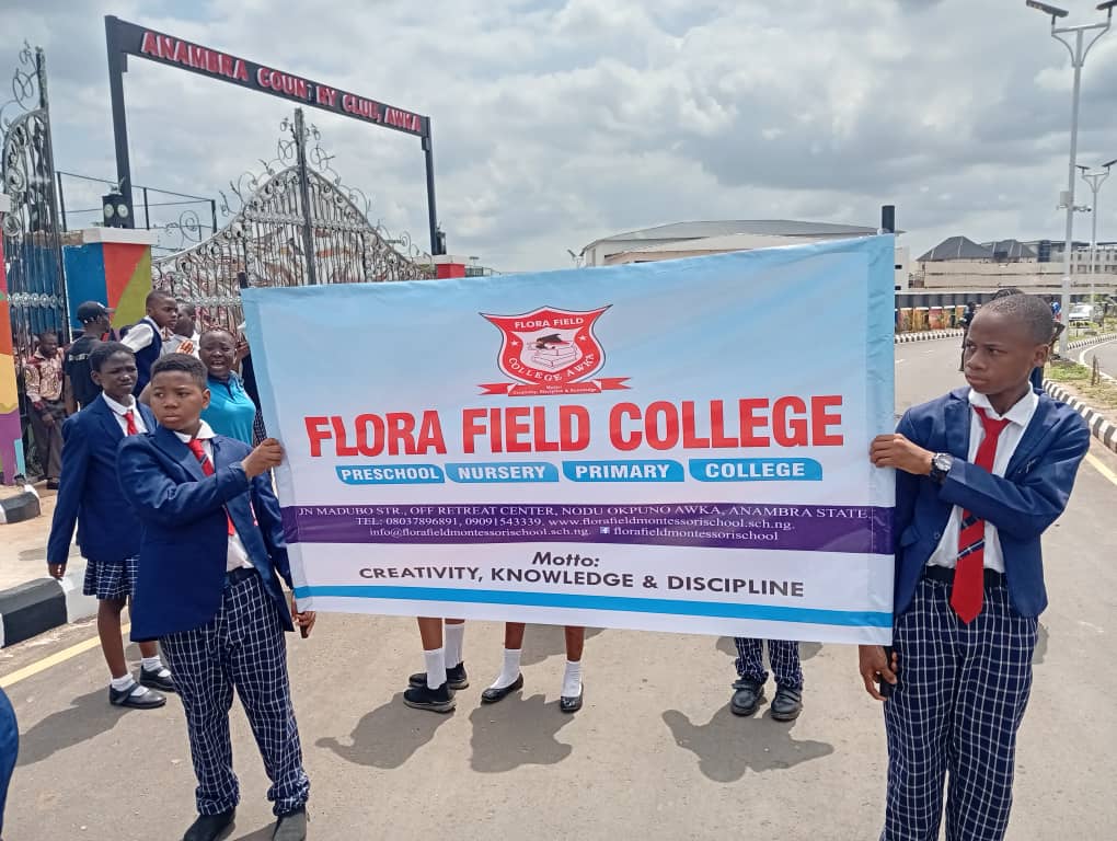 College students holding the Flora Field College banner