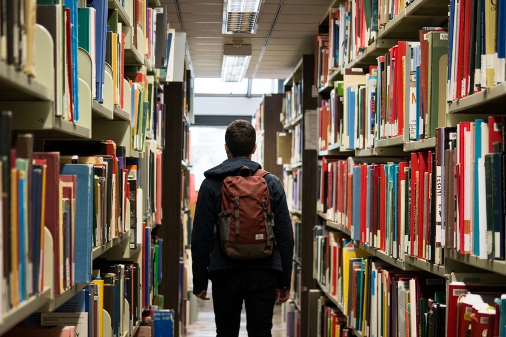 Student browsing the library shelves